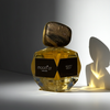 Perfume bottle labeled 'mood'or' with a dark label on a reflective surface.